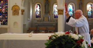 Fr. Phil Schneider places the Book of Gospels on the casket.