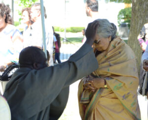 Fr. Anthony (visiting from Zambia) prays with a pilgrim.